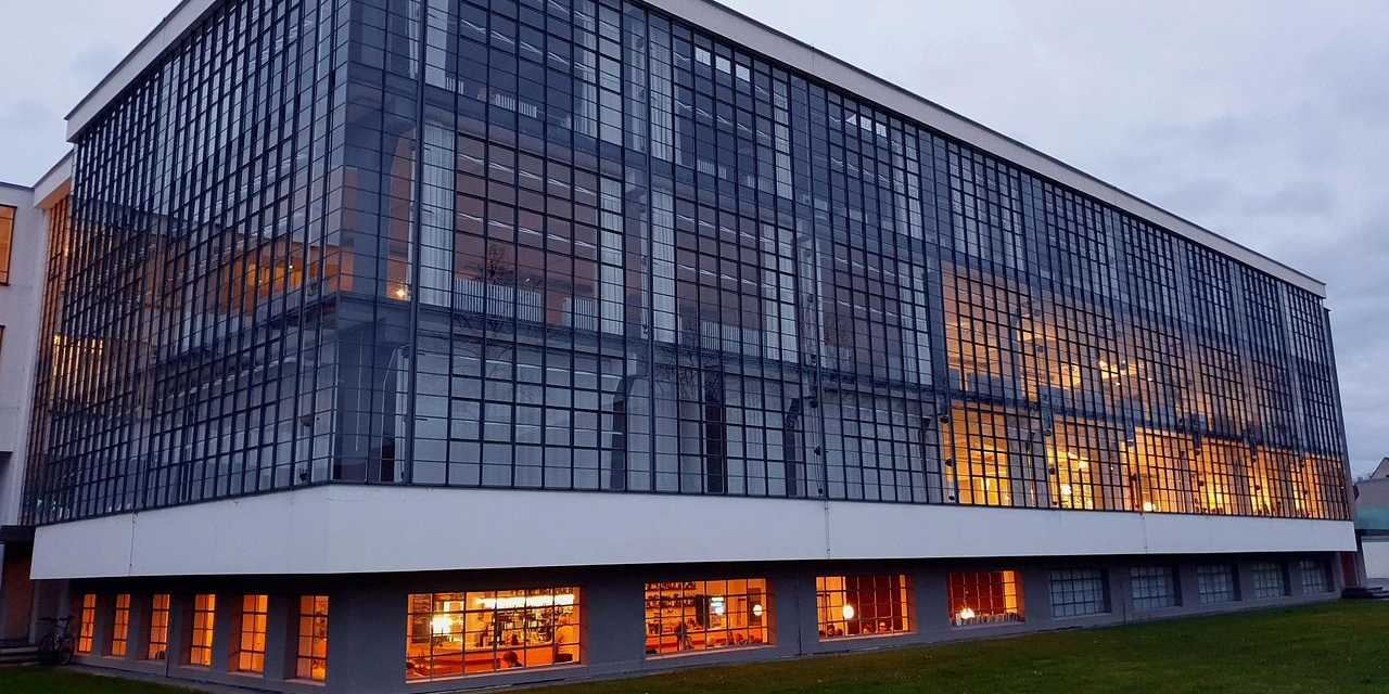Bauhausgebäude Dessau mit beleuchteter Glasfassade am Abend