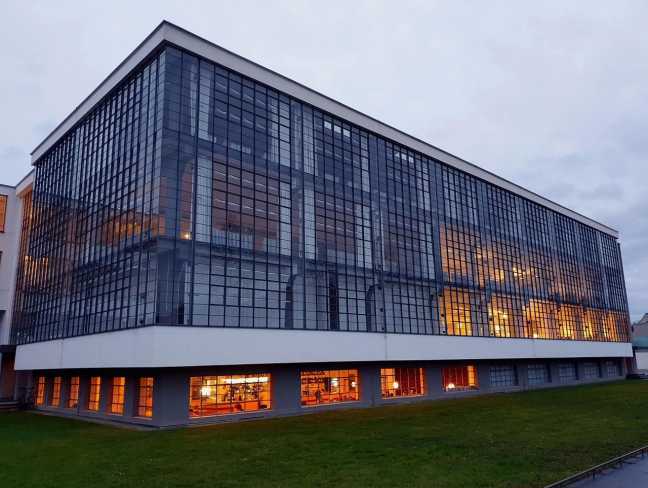 Bauhausgebäude Dessau mit beleuchteter Glasfassade am Abend
