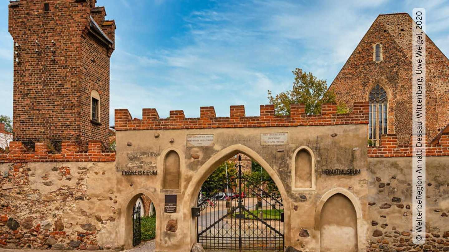 Außenansicht Francisceum - Blick auf das schmiedeeiserne Tor und Mauer