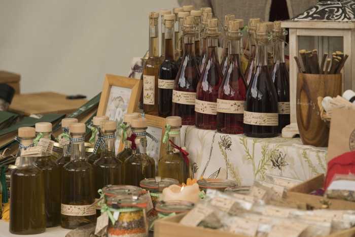 Flaschen mit Likören und Ölen auf einem festlich dekorierten Marktstand – Impression vom Reformationsfest in Lutherstadt Wittenberg